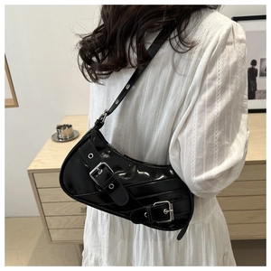 Détail du sac porté épaule noir brillant avec boucles argentées et style rétro Y2K