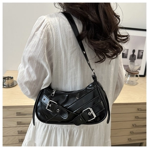 Détail du sac d'épaule en cuir verni noir avec boucles argentées et sangles punk