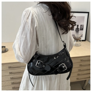 Détail du sac sous le bras en cuir noir brillant avec boucles argentées et sangles