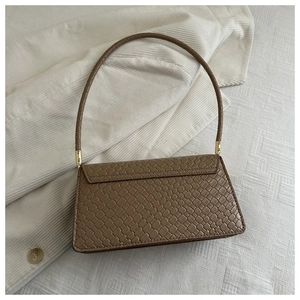 Detail der braunen Schlangenleder-Textur einer rechteckigen Handtasche mit Klappe