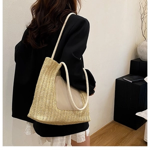 Detail of handwoven straw tote bag with rope handles and leather patch on a model back