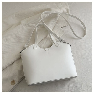 Close-up of a white bucket bag with matte faux leather texture and silver hardware details
