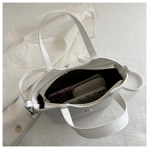 Top view of white bucket bag showing internal capacity with phone and wallet inside