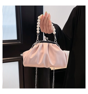 Close-up of light pink pleated cloud bag with pearl handle and silver chain strap