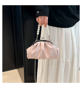 Detail of light pink pleated cloud bag with pearl handle and metal kiss lock