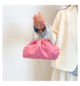 Close-up of pink ruched cloud bag featuring pearl handle and silver chain strap