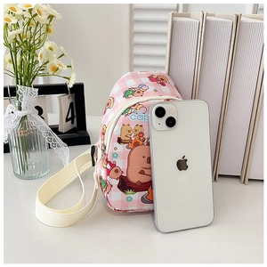 Detail of pink plaid Capybara crossbody bag with adjustable strap and phone for scale