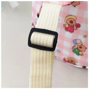 Detail of adjustable strap and pink checkered fabric with cute bear prints on cartoon bag