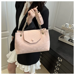 Close-up of light pink snake skin pattern texture on luxury chain shoulder bag for women
