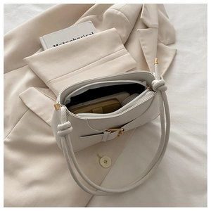 Internal view of a white leather shoulder bag showing zipper pocket and interior space