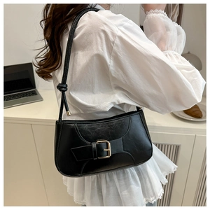 Detail of vintage black leather bag featuring sleek metal buckle and premium texture