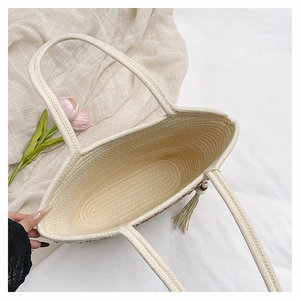 Detailed view of spacious woven tote interior with spiral texture and tassel charm