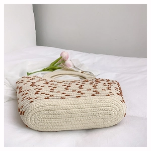 Detailansicht der gewebten Tasche in Creme mit braunen Punkten und Quasten