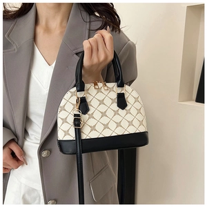 Détail du sac coquillage contrasté avec motif vintage et fermeture éclair dorée