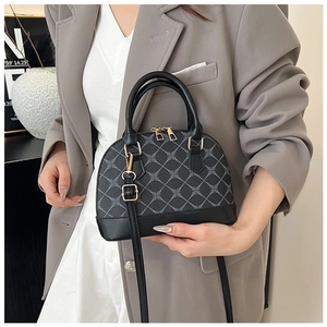 Détail d'un sac à main noir avec imprimés géométriques et fermeture éclair dorée