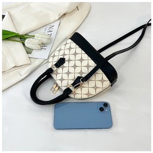 Détail du sac à main imprimé en forme de coquille avec finitions en cuir et zips dorés