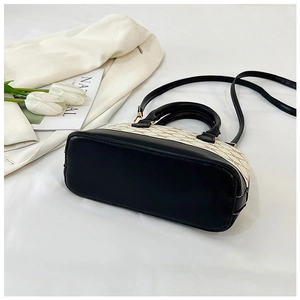Vue détaillée du sac à main bicolore crème et noir avec coutures contrastées élégantes