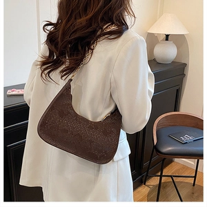 Detailed view of dark brown snakeskin textured crescent bag with golden chain strap