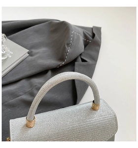 Détail d'un sac à main argenté pailleté avec texture scintillante et accents métalliques