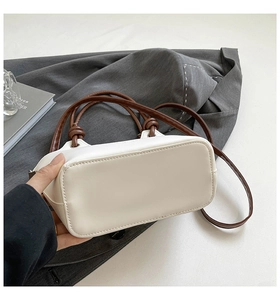 Detail view of rectangular flat base and high-quality stitching on a PU bucket bag