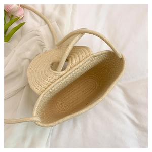 Close-up of cream woven crossbody bag showing spiral texture and spacious interior
