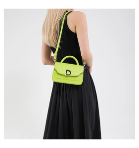 Close-up of vibrant neon green leather handbag featuring a silver D-letter buckle and top handle