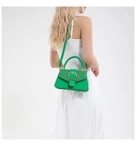Detail showing bright green handbag texture and golden buckle on white background