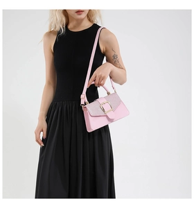 Close-up of pink leather handbag with glittery flap and gold buckle on a model