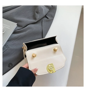 Detail shot of the cream PU leather shoulder bag with gold clasp and black lining