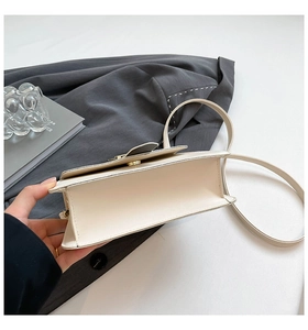 Interior view of the cream leather square crossbody bag with gold metallic snap button