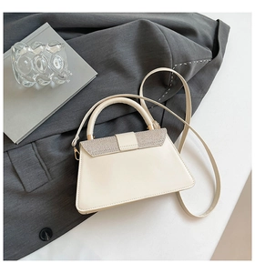 Close-up of beige trapezoid handbag with silver glitter flap and smooth faux leather
