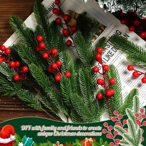 Macro detail of artificial pine needles with red berries and faux snow on wooden desk