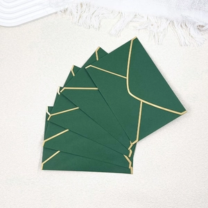 Detail of five dark green envelopes with elegant gold foil edges and V-flap design