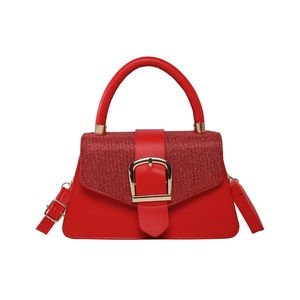 Glossy red handbag with sequins and gold buckle on a clean white background