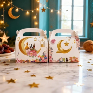 White Eid star and moon gift boxes with gold handles on an elegant marble background
