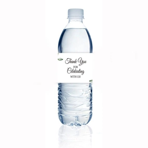 Close-up of white Thank You labels with eucalyptus leaves on clear water bottles