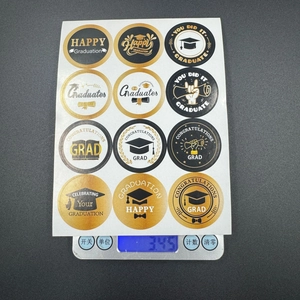 Macro detail of 12-piece black and gold graduation stickers on an electronic scale