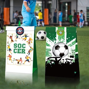 Fußball-Geschenktüten aus Papier mit Sportler-Silhouetten auf einem grünen Spielfeld