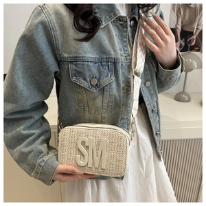 Detail of light beige woven crossbody bag with SM patch and patterned wide strap