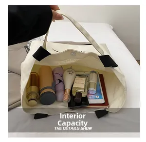 Detailed interior of a white canvas tote bag showing large capacity and snap button closure