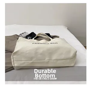 Detail view of the durable wear-resistant bottom on the white canvas tote bag