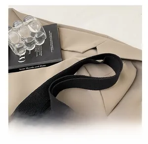 Detail of khaki canvas bag with wide black woven strap and high quality stitching