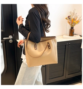 Detailed close-up of the beige and brown contrast leather stitching on the large tote bag