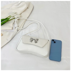 Close-up of white crossbody bag with silver bow buckle and woven leather texture detail