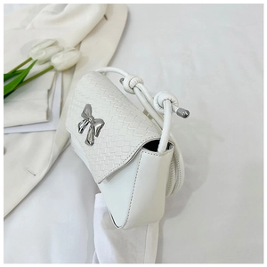 Close-up of white woven shoulder bag featuring a silver metal bow and rope strap