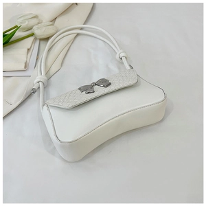 Detail of white leather shoulder bag featuring woven texture and silver bow buckle