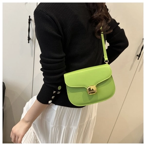 Détail du sac selle vert citron avec boucle carrée en métal doré et finition brillante