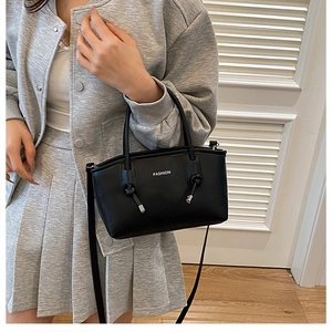Dettaglio della borsa tote nera minimalista con scritta fashion e tracolla sottile
