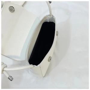 Macro shot of white shoulder bag showing magnetic silver buckle and black fabric lining