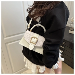 Detail der weißen gewebten Handtasche mit goldener Schnalle an einem Model